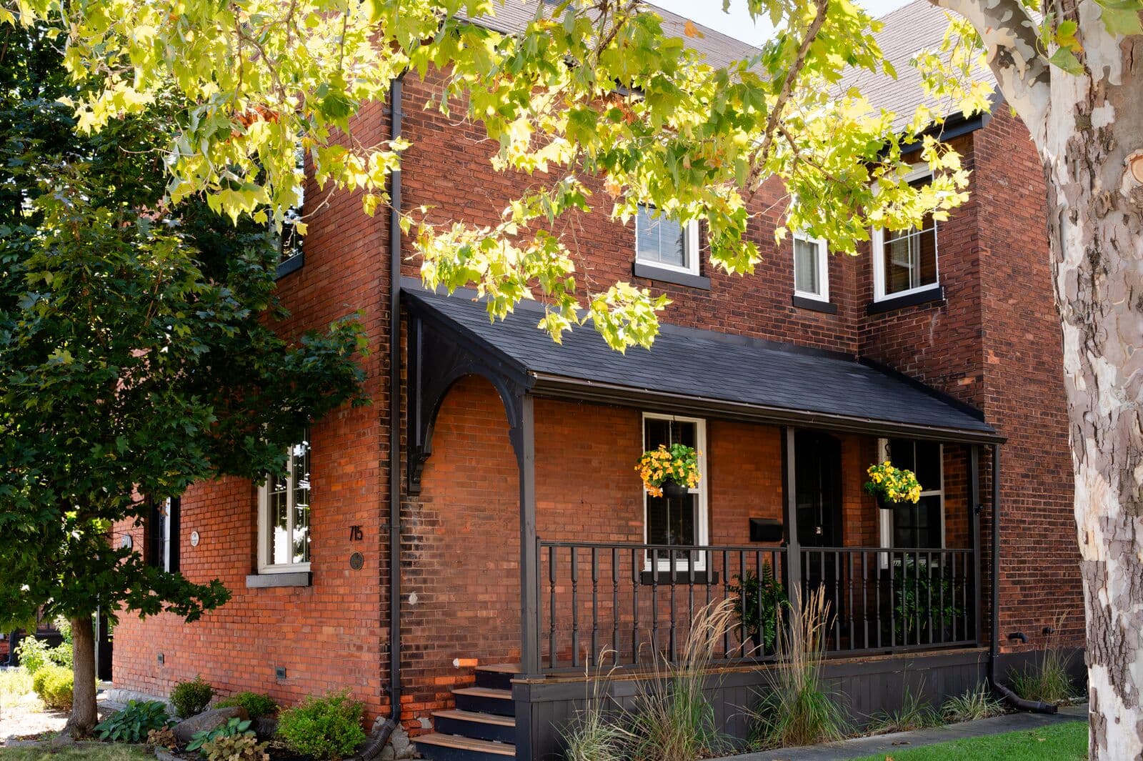 Covered front porch and entrance at 715 Walker Rd with hanging flower baskets